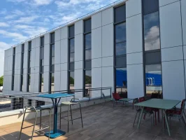 Terrasse extérieure aménagée avec mobilier coloré pour les pauses au centre d'affaires BURO Club Niort.