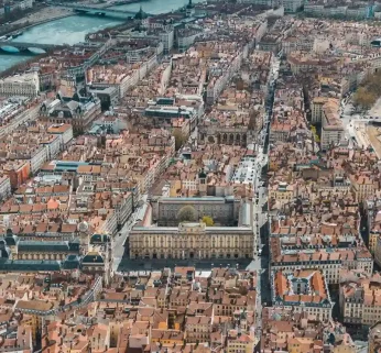 Panoramic aerial view of Lyon showing the confluence of the Saône, the Vieux Lyon district at the foot of Fourvière hill and the basilica dominating the city.