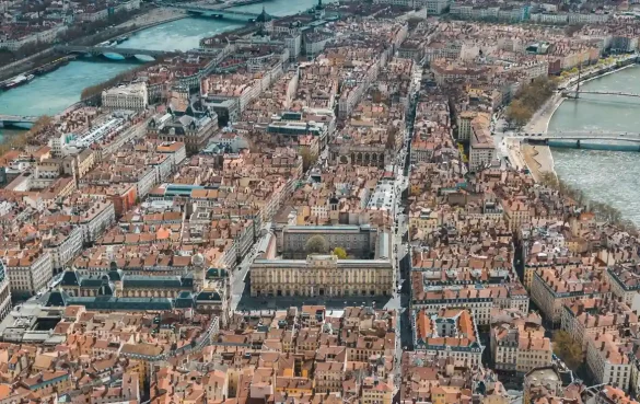 Panoramic aerial view of Lyon showing the confluence of the Saône, the Vieux Lyon district at the foot of Fourvière hill and the basilica dominating the city.