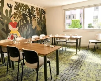 Perspective de la Loge Diego au BURO Club Partner Dijon Centre, une salle de réunion lumineuse avec moquette verte, table en bois disposée en U, et mur décoré d'une fresque mexicaine colorée type Frida Kahlo.