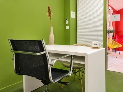 Bureau individuel au BURO Club Partner Beaune avec mur vert, bureau blanc, chaise ergonomique et décoration soignée.