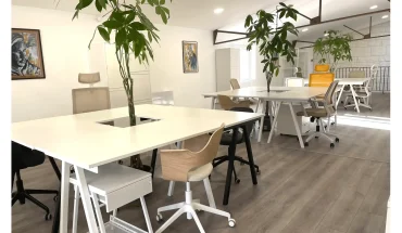 Postes de travail modernes et végétalisés dans l'espace de coworking BURO Club Partner Poitiers, avec fauteuils ergonomiques.