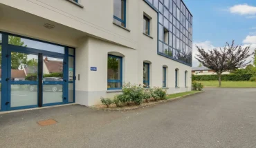 ntrée principale et façade vitrée moderne du centre d'affaires BURO Club au Mans avec parking.